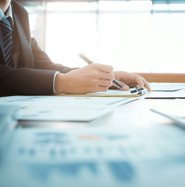 Businessman writing on notepad at desk