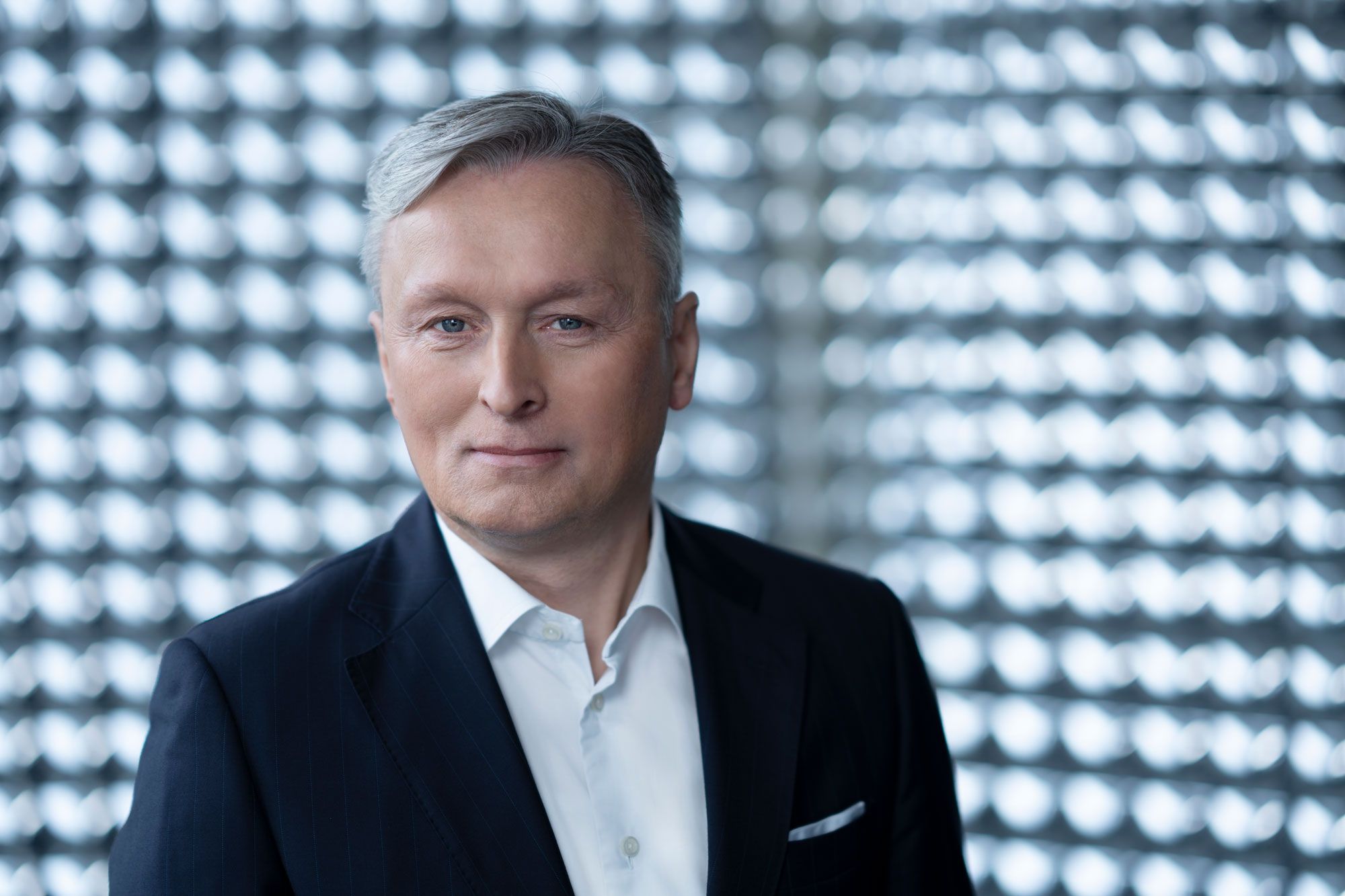 Man in suit and white shirt smiling