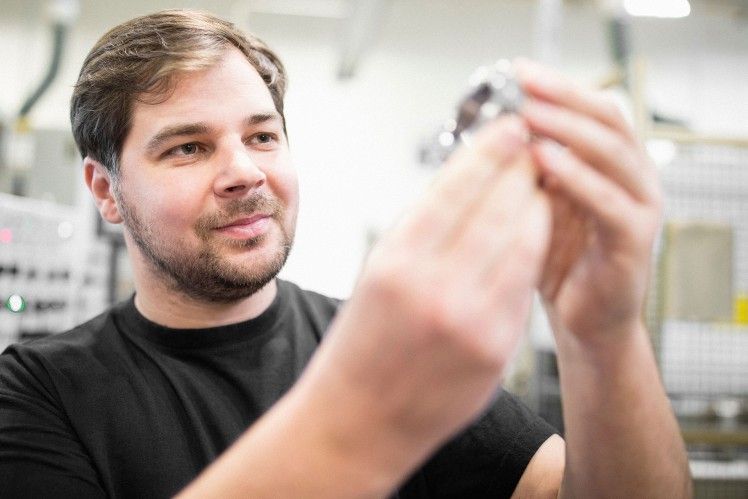 Man inspecting a car safety component in a factory