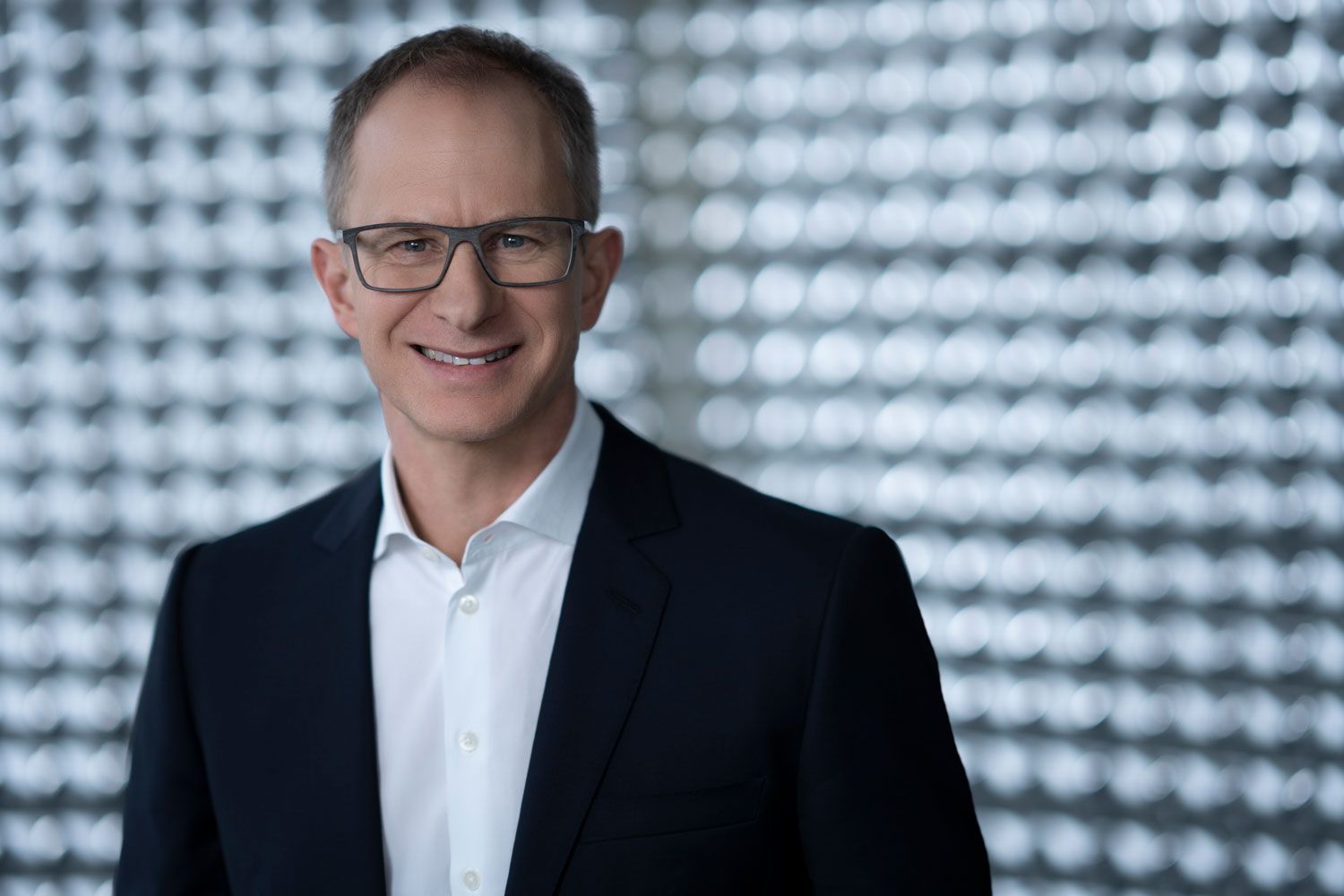 Man in suit and glasses smiling