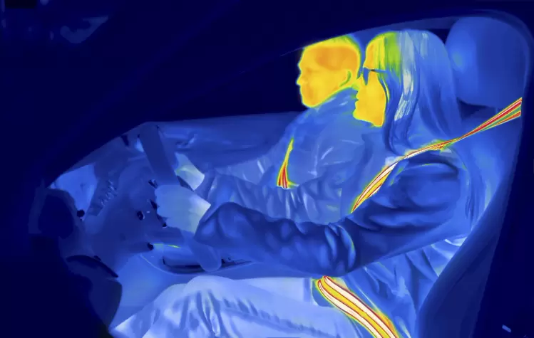 Thermal image of a car interior with highlighted safety belt and airbag deployment