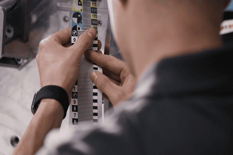 Person adjusting measurement scale on vehicle part