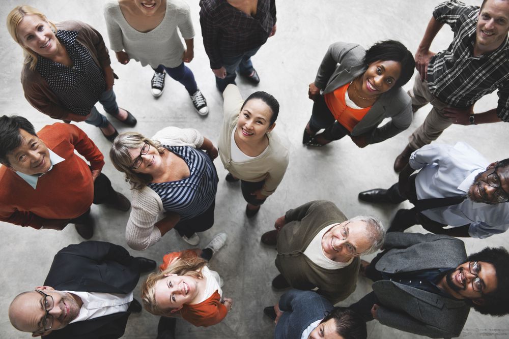 Diverse group of smiling employees looking up