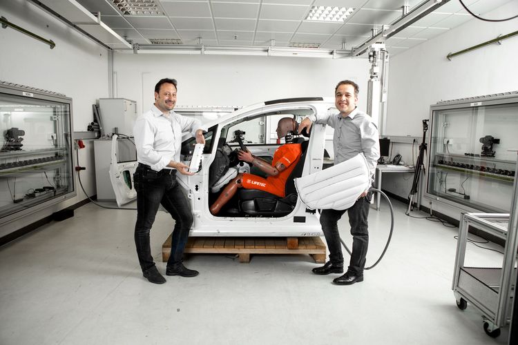 Two men demonstrating ZF Lifetec safety systems in a vehicle