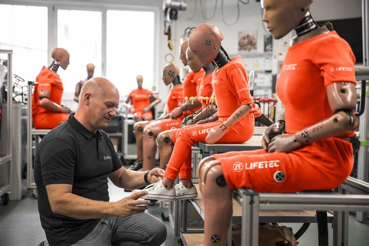 Man adjusting crash test dummy in ZF Lifetec lab