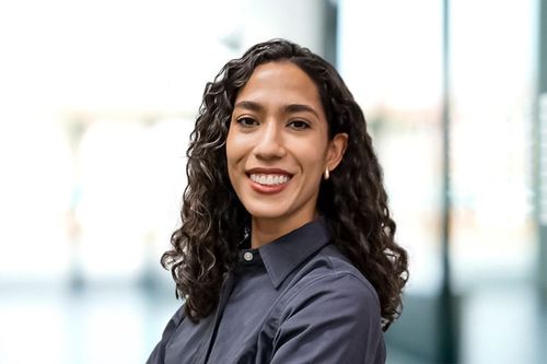 Smiling woman with curly hair wearing a blue shirt