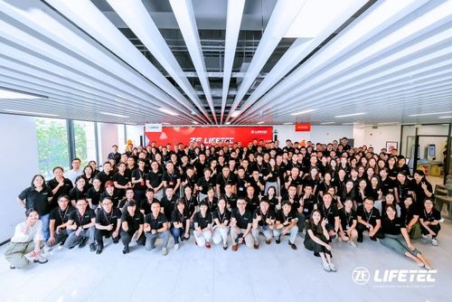 Large group of employees posing in front of ZF LIFETEC banner